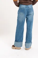 Jean wide leg de tiro medio, color azul claro, con botamanga amplia doblada.