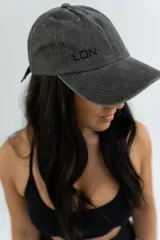 Gorro de gabardina color gris oscuro con visera curva y bordado frontal con la palabra "LON".
