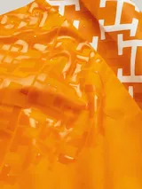 Short de baño naranja con estampado de monogramas TH en blanco a lo largo de la pierna.