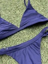 Conjunto de bikini azul con corpiño triangular fijo y bombacha colaless regulable.