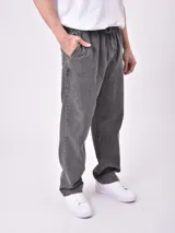 Pantalón gris de denim con efecto lavado, corte holgado, cintura elástica con cordón ajustable y bolsillos laterales.