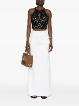 Top corto negro tejido a crochet con estampado floral, bordes festoneados y abertura en forma de lágrima.