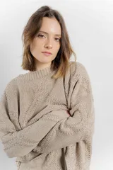 Sweater color arena de tejido geométrico con calce relajado, hombros caídos y terminaciones suaves.