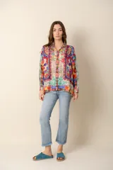 Camisa de mangas largas con cuello clásico y cierre frontal con botones. Estampado multicolor con motivos florales y geométricos.
