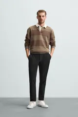 Pantalón largo de vestir gris claro con estampado de cuadros, corte slim fit y cintura elástica. Confeccionado en tejido con alta elasticidad, bolsillos frontales y cierre frontal con cremallera y botón.