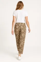 Pantalón babucha marrón con estampado floral en tonos beige, con cintura elástica ajustable con cordón.