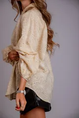 Camisa celeste con estampado de flores blancas, corte clásico, cuello camisero y mangas largas abullonadas.