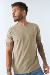 Remera color arena de algodón, corte regular, manga corta, cuello redondo y bolsillo en el pecho con estampado de texto.