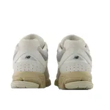 Championes urbanos New Balance modelo U2002Rj, color beige con detalles en gris, confeccionados en gamuza y malla, con logo "N" característico en los laterales y entresuela ENCAP.