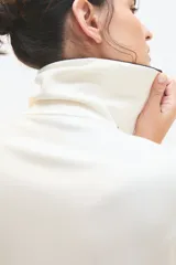 Buzo negro de corte holgado con cuello alto con cierre metálico y mangas largas con puños elásticos.