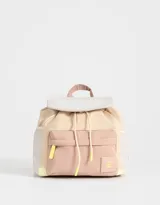 Mochila color beige con detalles en rosa y amarillo, de tela deportiva con diseño colorblock. Tiene solapa con tira de ajuste de cordón y goma, correas regulables, manija superior, bolsillo frontal con cierre y tag de goma, y bolsillos laterales.