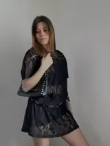 Vestido corto tipo remera de encaje negro con mangas cortas y cuello redondo.