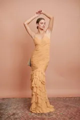 Vestido largo color durazno, entallado, con escote en V, breteles finos, drapeado en el frente y falda con volados.