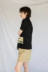 Camisa negra de manga corta con botones nacarados y corte estampado en el delantero.