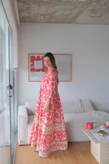 Vestido largo color rojo con estampado floral blanco y beige, corte amplio y mangas 3/4.