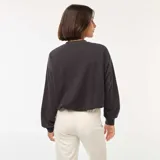 Buzo negro de corte holgado, con cuello redondo y mangas largas.