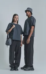 Remera de manga corta color gris oscuro (gris mamba) con calce boxy fit. Presenta un pequeño logo bordado en el pecho.