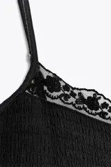 Vestido corto color salmón, de escote recto y tirantes finos ajustables. Presenta detalle de encaje en el escote y falda de tres niveles.