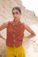 Top tejido color terracota con lurex dorado, espalda calada estilo red y cuerdas frontales para atar. Puede usarse como chaleco.