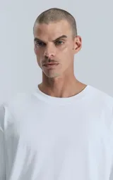 Remerón blanco de corte extra oversize y hombros caídos, confeccionado en algodón premium americano muy suave al tacto. Cuello rib redondo al tono con doble costura.