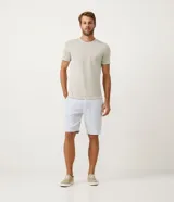 Bermuda de hombre en lino color gris claro, de corte recto, con textura discreta, bolsillos laterales y cierre frontal con botón y cremallera.