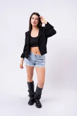 Blazer negro de corte estructurado, con solapas de muesca, manga larga con puños doblados y bolsillos frontales.