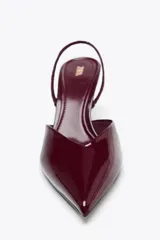 Zapato destalonado color beige acharolado, con escote en pico, tira trasera ajustable y tacón fino.