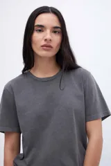 Remera gris de algodón con cuello redondo y mangas cortas. Diseño liso con efecto gastado.