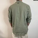 Camisa blanca de lino con corte regular, cuello clásico y mangas largas con puños abotonados.