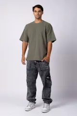 Remera de hombre color crudo, corte oversize, confeccionada en algodón grueso con textura micropanal. Diseño liso sin logos, con costura en forma de 'X' en la espalda. Ideal para un look casual y relajado.