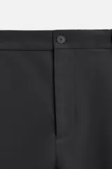 Pantalón relaxed fit color verde oscuro, con pliegues en la parte delantera, bolsillos laterales y traseros de ojal. Cierre frontal con cremallera y botón.