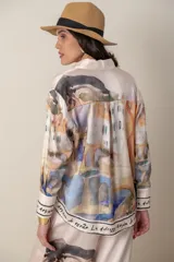 Camisa de satén de seda estampada, de color natural con estampado en tonos de naranja, verde y lilas, con puños anchos y terminación de guarda.