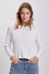 Remera blanca de algodón con textura acanalada, corte ajustado y mangas largas.