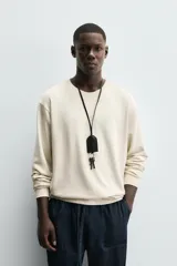 Sudadera color beige claro con cuello redondo y mangas largas.