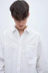 Camisa celeste de algodón, corte regular fit, con cuello solapa clásico, manga larga, bolsillo en el pecho y botones personalizados.