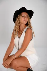 Chaleco tejido celeste con terminaciones en punto festón negro.