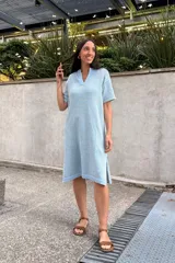 Vestido tejido color verde claro, con escote en V, mangas cortas y aberturas laterales.