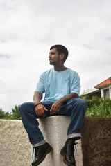 Remera color arena de corte recto y mangas cortas, con cuello redondo y estampado pequeño en el pecho con una carita sonriente y la palabra "Tuya.".
