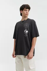 Remera negra de manga corta con corte oversize y estampado gráfico blanco en el frente que incluye un mapa del mundo y figuras geométricas.