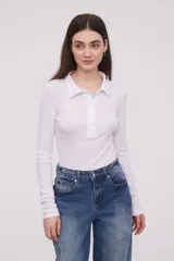 Remera de corte ajustado color negro con manga larga y cuello polo, botón frontal.