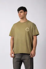 Remera verde militar de algodón con efecto lavado gastado y corte oversize. Estampa circular blanca con texto "VCP CONCEPT STUDIO" en el frente.