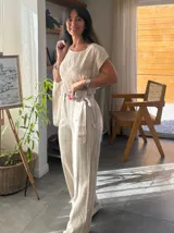 Pantalón de lino color blanco con finas rayas verticales negras, de corte recto y tiro alto.