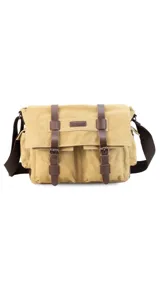 Morral de tela canvas color gris con detalles en cuero marrón. Tiene tapa con hebillas, doble bolsillo frontal, trasero y laterales. Interior espacioso con compartimento para notebook de 15". Correa de galón regulable.