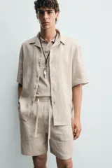 Bermuda negra de lino con calce relajado. Presenta cintura elástica ajustable con cordón, bolsillos frontales y un bolsillo trasero de plastrón.