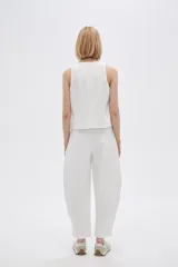 Pantalón blanco de poliéster, corte ancho, tiro alto y bolsillos laterales.