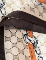 Pañuelo cuadrado de satén estampado con diseño de cadenas, hebillas y el logo de la marca.