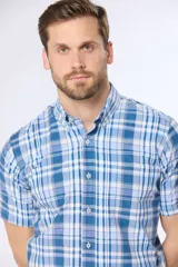 Camisa de manga corta con cuello abotonado y estampado a cuadros en tonos de azul y blanco. Hecha en Uruguay.