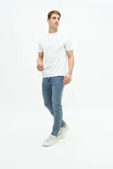 Remera blanca de manga corta con cuello redondo y estampado pequeño en el pecho con una columna griega y texto en color celeste.