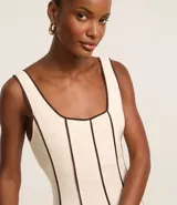 Vestido largo evasé sin mangas, confeccionado en viscolino con 15% de lino. Presenta escote cuadrado en el busto y escote en U en la espalda, con cierre trasero por cremallera. Posee bieses contrastantes.