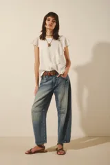 Remera blanca de algodón con mangas cortas con volados de encaje y detalle de volado vertical en el frente.